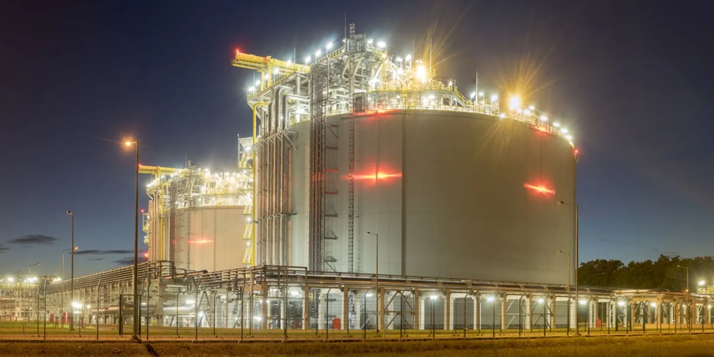 Illuminated LNG storage tanks and pipework at night